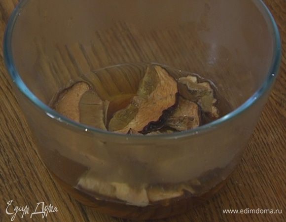 Сухие грибы замочить в кипятке, дать настояться, затем слить воду через сито в отдельную посуду.