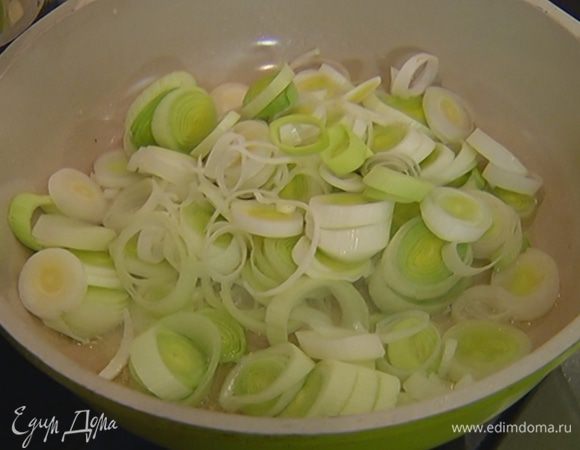 Разогреть в сковороде 2 ст. ложки оливкового масла и обжарить порей до прозрачности.