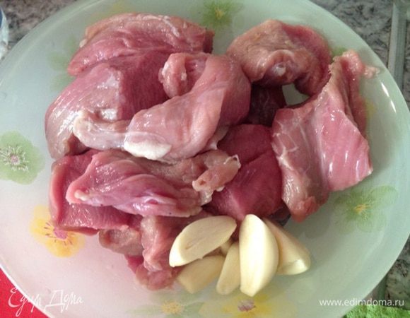 Мясо порезать, чеснок почистить.