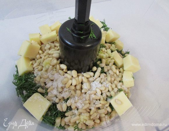 Подготовленный ингредиенты выложить в чашу блендера. Измельчить укроп, чеснок, орехи и сыр. 