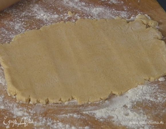 Рабочую поверхность присыпать оставшейся мукой, выложить тесто и раскатать в пласт толщиной 0,5 см.