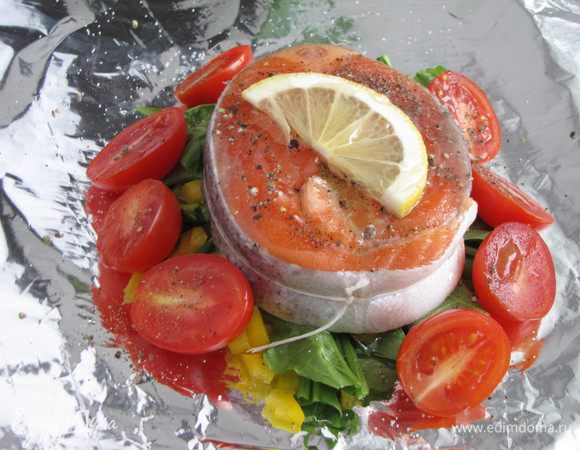 Сверху на овощи выложить подготовленную рыбу, вокруг расположить помидоры черри.  Сбрызнуть  оливковым маслом, игристым вином, посолить, поперчить.  Сверху положить пластик лимона.