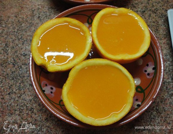 Половинки апельсинов поместить в контейнер или удобную, устойчивую посуду и залить желе. Немного остудить и поставить в холодильник до полного застывания.