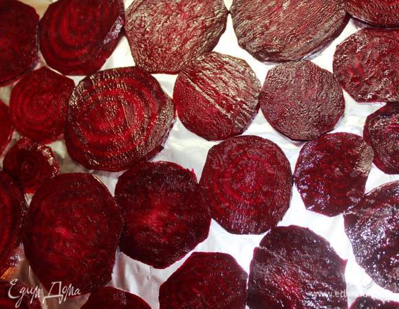 Для начала приготовим полезные чипсы.
Разогреваем духовку до 160 градусов.
Сырую свеклу очистим и нарежем тонкими ломтиками, чем тоньше, тем быстрее время приготовления. 
Лучше брать свеклу средних размеров, чтобы чипсы получились «на один укус». По крайней мере, мне так больше понравилось.
Поливаем оливковым маслом и хорошенько перемешиваем в миске, чтобы масло равномерно распределилось (надежнее это делать руками). Выкладываем на противень в один слой. 
По желанию можно посолить и поперчить по вкусу.
Ставим в разогретую духовку минут на 30-50 (зависит от толщины и размера). Еще быстрее будет, если в вашем духовом шкафу есть режим конвекции.
