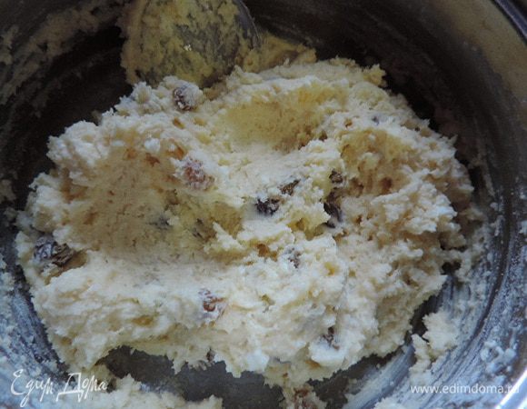 Просеиваем на тесто муку с содой, высыпаем промытый и обсушенный изюм. Замешиваем ложкой тесто.