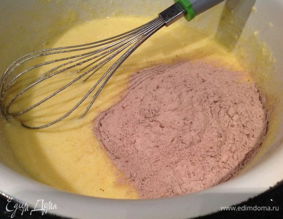 Добавьте в яично-масляную массу муку с какао.