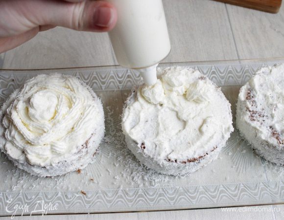 Затем сливки накладываем в кондитерский мешок и выдавливаем  сверху пирожных. Украшаем еще любыми шоколадными фигурками и посыпаем слегка какао.