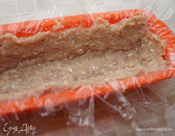 Включить разогреваться духовку до 200 градусов. 
Делаем рулет: форму для выпечки кекса (хлеба) выстилаем пищевой плёнкой со свободно свисающими концами, за них мы потом будем вытаскивать наш рулет из формы. Укладываем 2/3 фарша, делаем бортики.