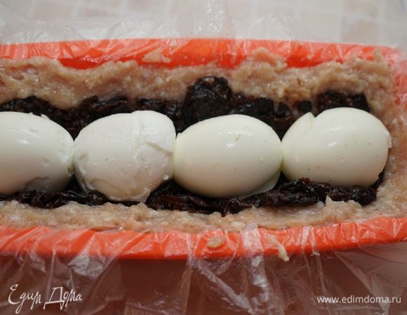 На него кладём подготовленные яйца, стараясь, чтобы они оказались в центре рулета, а промежутки между ними были заполнены черносливом.