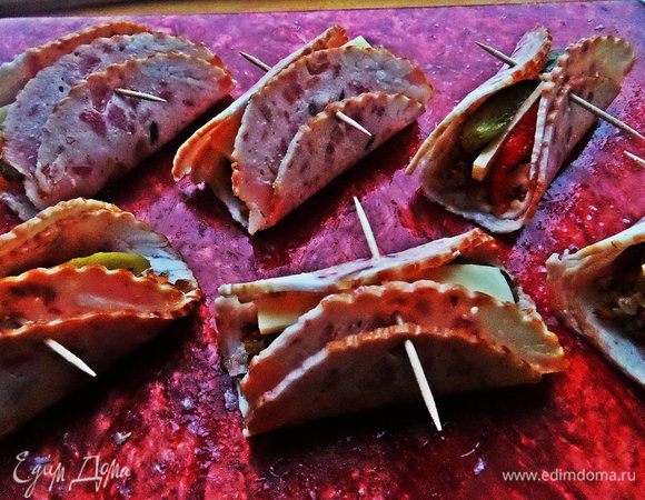 Сворачиваем, скрепляем зубочистками. Если у Вас ветчина более широкая, можно свернуть трубочкой.