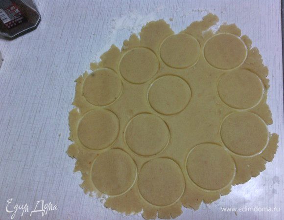 На посыпанной мукой поверхности раскатать тесто в пласт толщиной 3-4 мм и вырезать кружочки диаметром 5-8 см.

Выложить на противень и выпекать в нагретой до 190° С духовке в течение 12 мин.