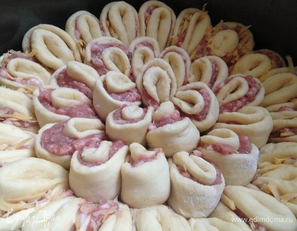 Разъемную форму 28 см выстелить пергаментом и смазать маслом. Плотно выложить в нее все лепестки. Когда закончится 1-я часть теста, со 2-й поступить аналогично. 