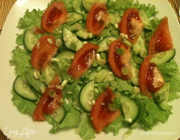 Поверх салатных листьев уложить нарезанные тонкими ломтиками помидор и огурец.