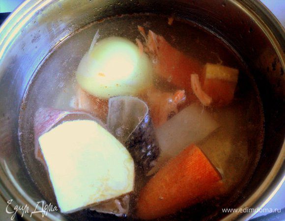 Хребтовую кость, кожу и обрезь семги залить 0.5 л вода, довести до кипения. Добавить лук, морковь и корень сельдерея. Варить на небольшом огне 15 -20 минут.