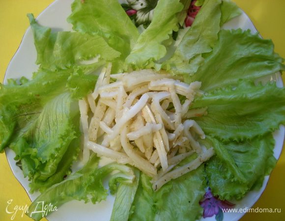 Кальмар разрезать на полоски и выложить на салатные листья.
