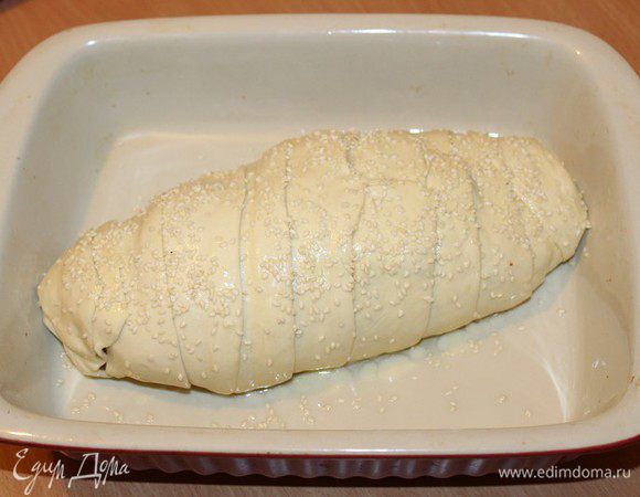 Внахлест накладываем тесто на мясо. (делаем мумию,,). Обмажем взбитым яйцом и посыпем кунжутом. Ставим рулет в духовку на 1 час 15 минут. Первые 45 минут выпекаем при 200 градусах, затем при необходимости накрыть фольгой и готовить его еще 30 минут при 170 градусах.