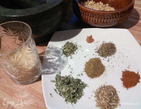 Через полтора часа, когда мясо будет готово, вынем его, в этот момент я его режу на порционные кусочки, процедим бульон, вернём в него мясо, посолим   и насыпем полстакана обыкновенного круглого риса и продолжим варку. 
Подготовим травы и специи. В ступке размелем чёрный перец и кориандр. Вместо аджики можно использовать красный жгучий перец. 