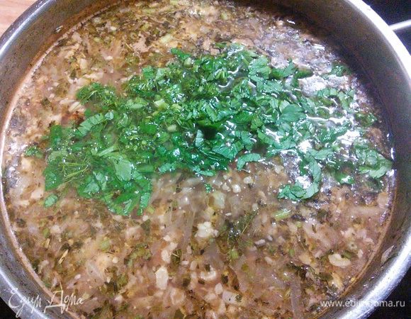 Как только рис будет готов, снимем кастрюлю с огня. Разотрём 3-4 зубчика чеснока и заправим харчо чесноком и свежей зеленью кинзы, базилика и сельдерея, их при этом не жалеть! 