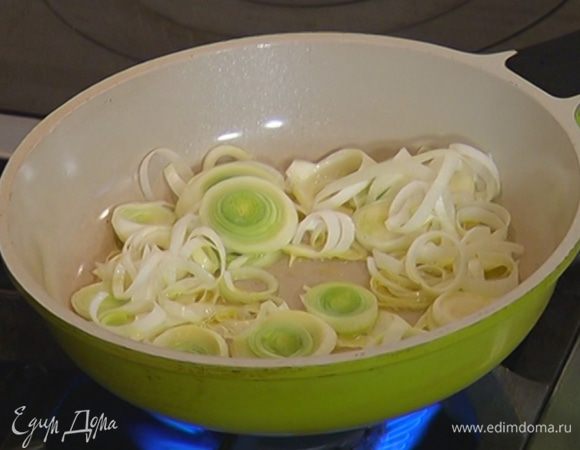 Разогреть в сковороде 2 ст. ложки оливкового масла и обжарить порей до прозрачности.