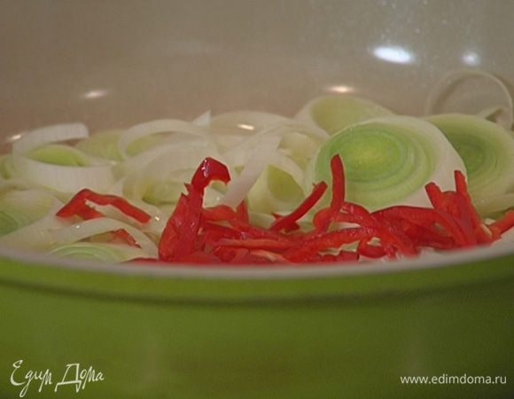 Перец чили, удалив семена, нарезать тонкими полосками и добавить в сковороду к порею.