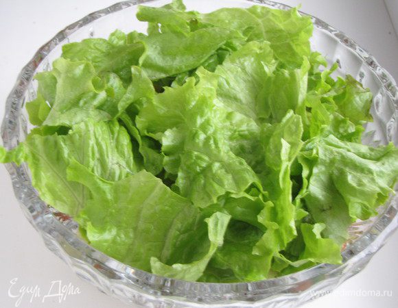 Выложить подготовленные овощи в салатник. Нарвать руками салатные листья и укрыть ими салат.