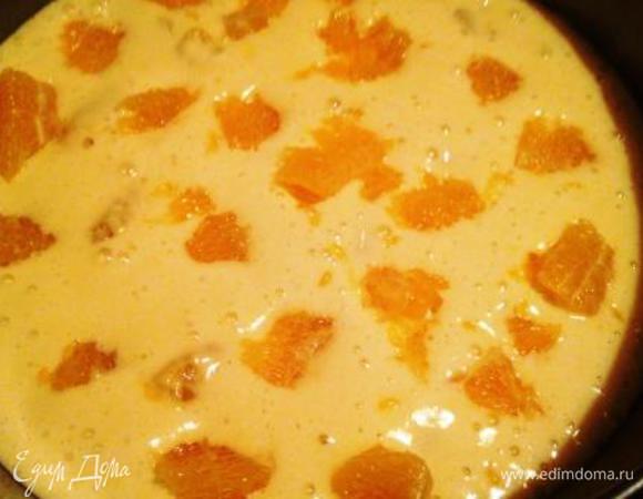 В проложенную пергаментом и смазанную маслом форму 24 см вылить треть теста, сверху выложить половину апельсинов, вылить вторую треть теста, распределить оставшиеся апельсины и покрыть остатками теста.