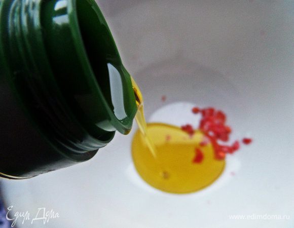 Для заправки наливаем в пиалочку оливковое масло и покрошим немного стручка чили для пикантности.