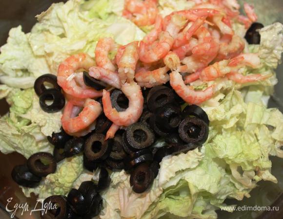 В салатнике перемешиваем капусту, маслины, куриные яйца и креветки. 

