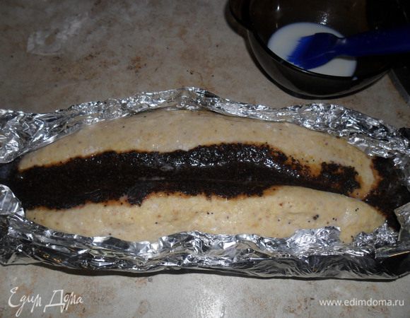 Выложить начинку на тесто, свернуть в рулет от краев к середине, смазывая при этом тесто молоком с помощью кисточки. Из фольги сделать формочку, и переложить туда рулет. Затем смазать растопленным маслом.