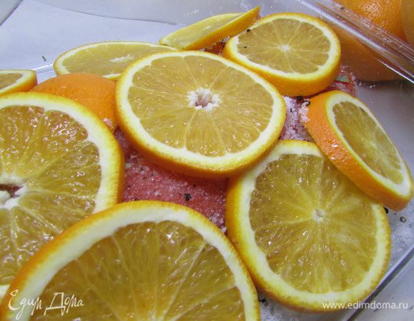 Затем покройте полностью филе форели кружочками апельсина.