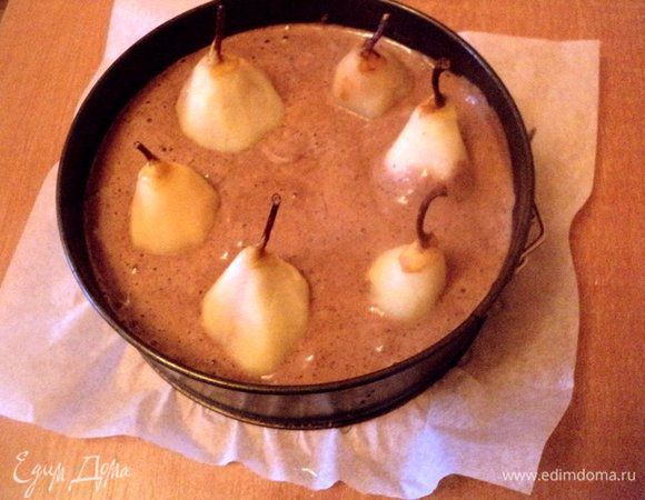 Муку смешать с какао и разрыхлителем. ¼ стакана уваренного сиропа смешать с растительным маслом и цедрой апельсина. В несколько приемов всыпать в яичную массу мучную смесь и жидкую смесь, перемешать до однородности. Дно формы Ф-20 см застелить бумагой для выпечки, смазать маслом. Вылить в форму тесто и погрузить в тесто груши.