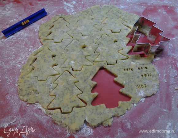 Присыпаем рабочую поверхность мукой. Раскатаем тесто в пласт толщиной около 0,5 см. Слишком тонко не раскатываем!

Формочкой вырезаем новогодние фигурки. Я еще с помощью штампа поставила на каждом печенье "2015")))