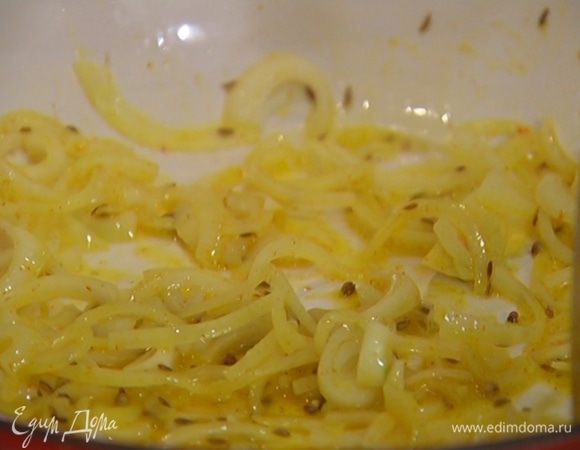 В тяжелой сковороде со съемной ручкой разогреть 1–2 ст. ложки оливкового масла и сливочное масло, выложить лук и чеснок, добавить семена кориандра, тмин, имеретинский шафран и все обжарить.