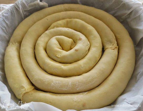 Выкладываем по кругу фаршированные колбаски (рулеты), формируя спираль.