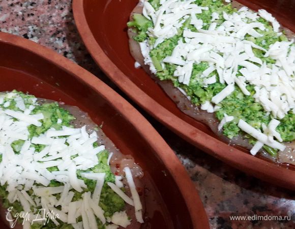 Глиняные тарелки смазываем оливковым маслом и выкладываем грудку плотными волокнами вниз, т.е. кусочки с верхней ее части, чтобы начинка никуда не "убежала".
Посыпаем сыром, затем выкладываем брокколи, приминая пальцами, и снова посыпаем сыром.
Немного сыра оставляем, выдавливаем в него чеснок и перемешиваем.