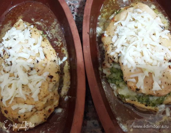 Через полчаса достаем тарелки, поливаем курицу образовавшимся соусом, посыпаем сыром с чесноком и снова отправляем в духовку до образования румяной корочки.