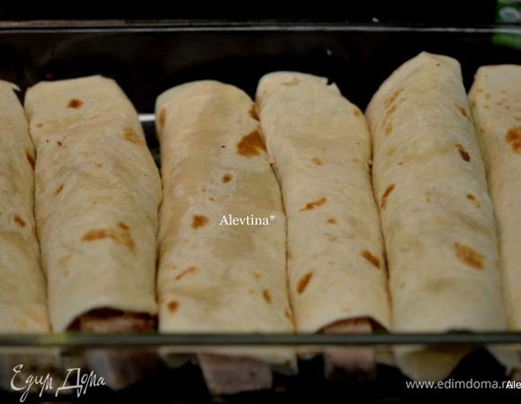 Выкладываем поверх лепешки свинину. Можно добавить к ней замороженную кукурузу,1 ст. л. на лепешку.Заворачиваем и выкладываем каждую лепешку на смазанную форму.
