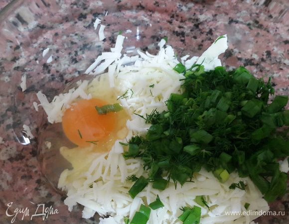 Сыр натираем на крупной терке, вбиваем яйцо и добавляем рубленую зелень.