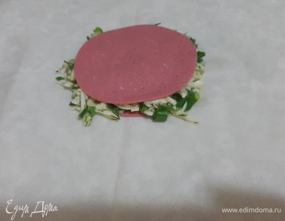 Тонкий лаваш делим на 2 части. Выкладываем в середину очень тонкий ломтик колбасы, сверху начинку и снова колбасу.