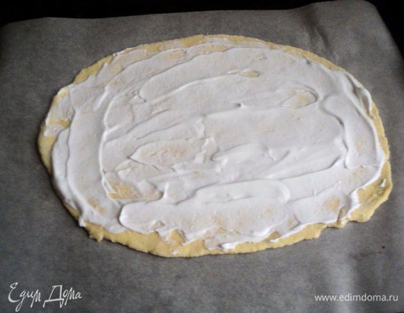 Отделить от теста 1/4 часть и раскатать в овал толщиной 5-6мм и выложить на противень, застеленный бумагой для выпечки. Смазать пласт белковым кремом. Это будет основа тела овечки.