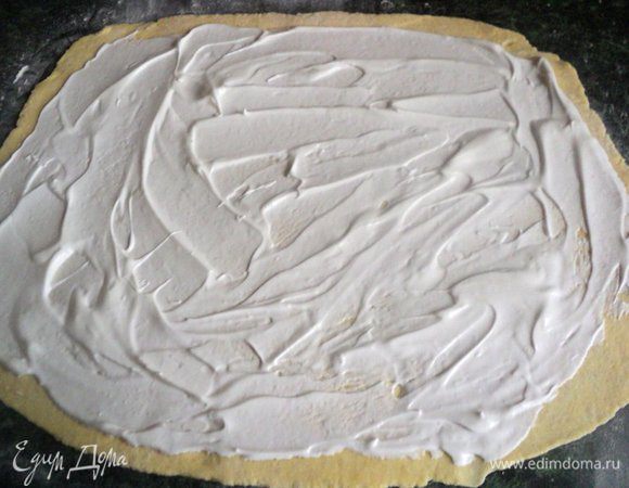 Отделить от  теста небольшой кусочек для головы и ножек овцы, остальное тесто раскатать в пласт толщиной 5 мм, смазать белковым кремом.