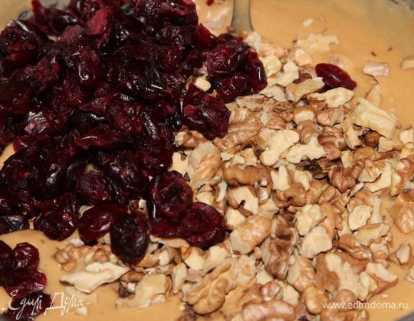 Добавить вяленую клюкву и крупно колотые орехи.