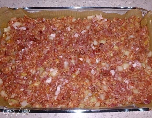 Выложить массу на бумагу для запекания в форму и примять руками. Посыпать кубиками бекона и запечь в духовке 45 минут.