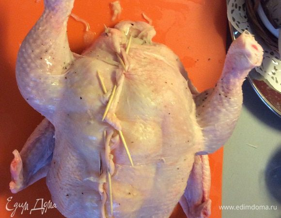 Берем квашеную капусту и заполняем ей всю внутренность курицы. Плотно набивая ее внутри. Зубочистками закрываем надрезанный животик. 