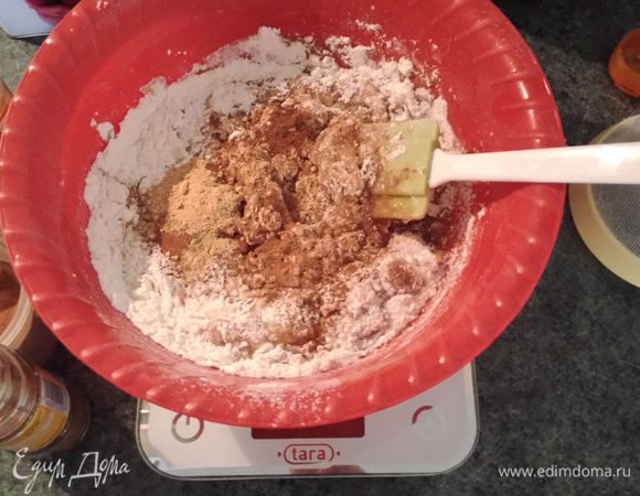 Вылить горячий мед на муку, смешанную с разрыхлителем, сахаром, ванилином и специями. Тщательно перемешать.