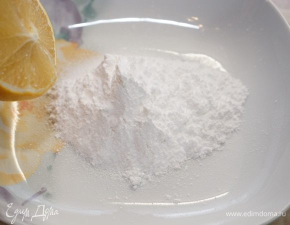 Приготовить глазурь. В тарелку просеять через сито сахарную пудру и добавлять по одной ст. ложке лимонный сок, растирая массу ложкой. Нужную густоту регулируйте добавлением лимонного сока. Мне понадобилось полных 2 ст. ложки сока.