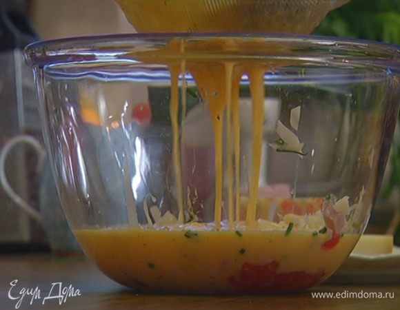 В отдельную посуду выложить нарезанные помидоры, ветчину, сыр и шнитт-лук, затем через сито влить взбитые яйца.