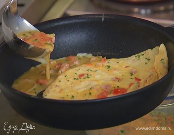 Как только яичный корж схватится, немного завернуть один его край наверх, сдвинуть омлет на освободившееся место и половником влить еще немного яичной массы.