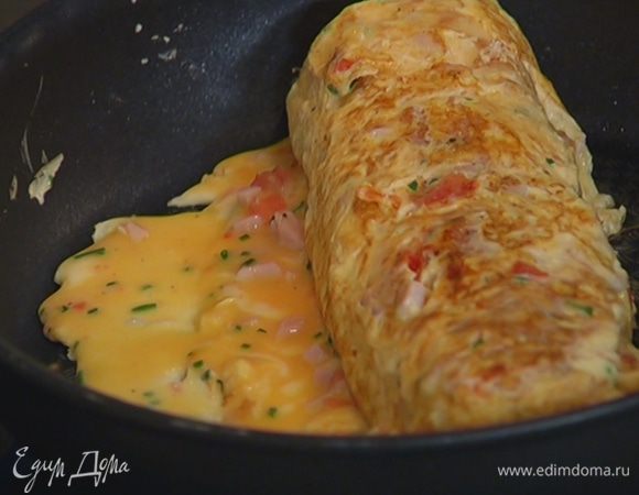 Продолжая сворачивать омлет с одного края в рулет, порциями доливать оставшуюся яичную массу. При необходимости смазывать кисточкой сковороду оливковым маслом.