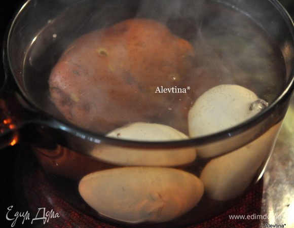 Отварить до готовности картофель и яйца. Очистить готовый картофель и порезать кубиками. Яйца очистить и порезать пополам.